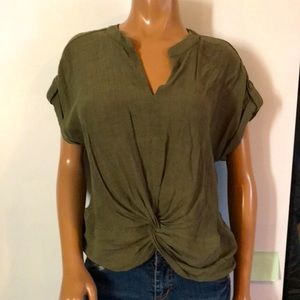 Army green twist top that hangs longer in the back to the top of pockets.